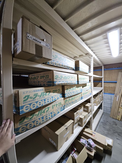 エアコン用配管パイプや箱入り部材が保管された棚
