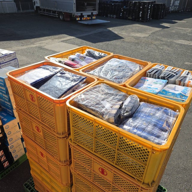 コンテナに整理された作業服や作業用品の買取品
